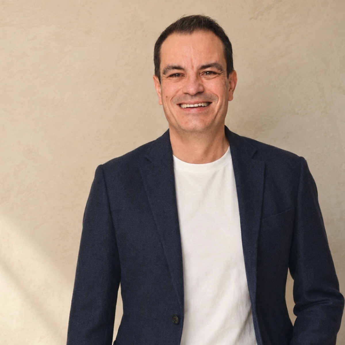 Mikon Raab lächelt in einem dunkelblauen Blazer